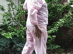Tranny slut in pink PVC boiler suit outdoors